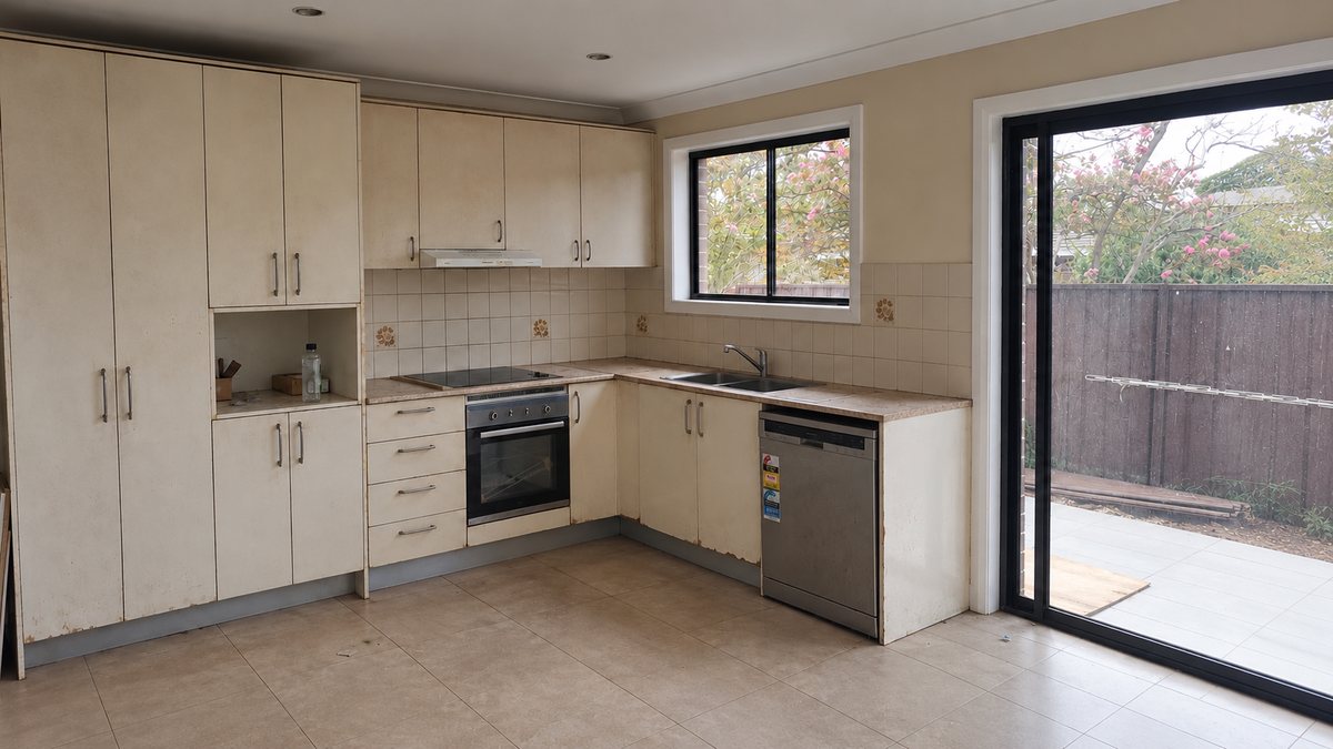 Chipping Norton kitchen before renovation, with pale timber cabinets, floral tile splashback and a freestanding oven