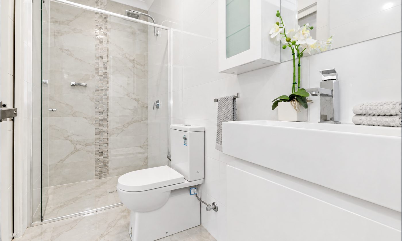 Moorebank bathroom with a marble-look tiled shower, wall-hung vanity and orchid