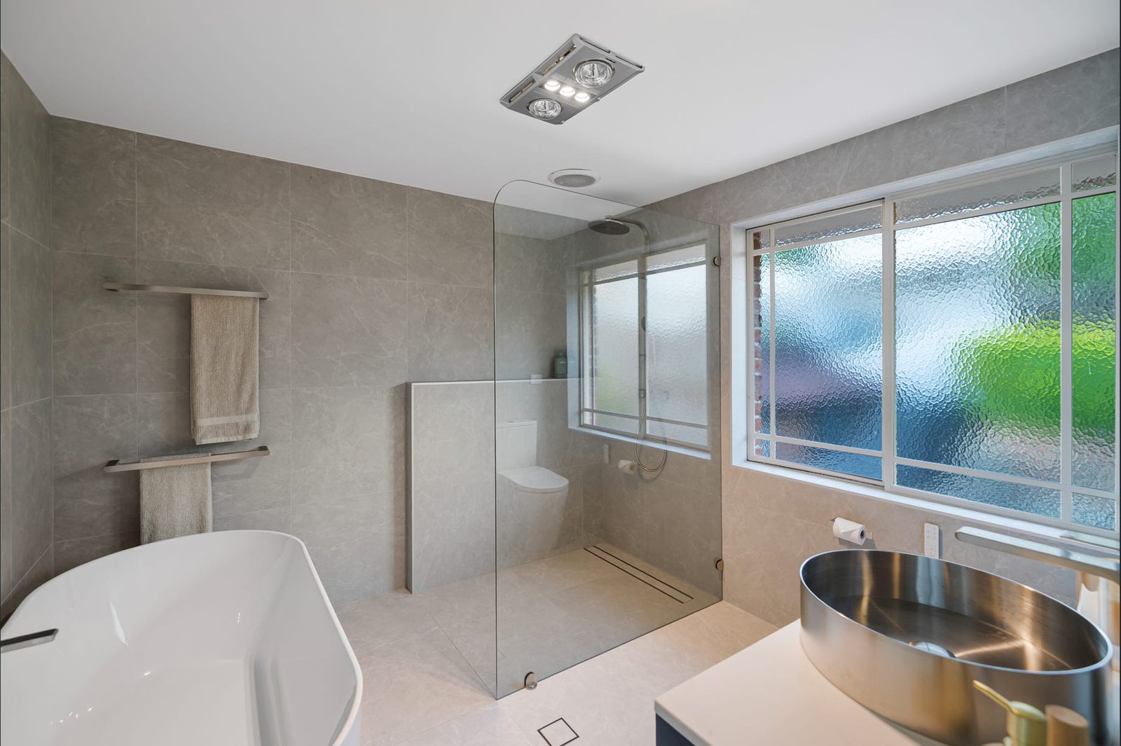 Padstow Heights bathroom with a freestanding bath, frameless glass shower and steel basin